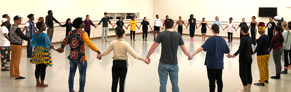 Dancers standing in circle joining hands