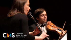 Romie de Guise-Langlois plays the clarinet, with a violin player in the background.