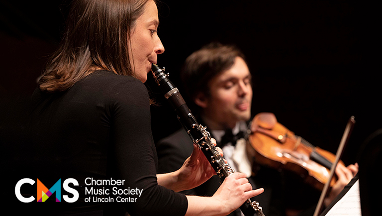 Romie de Guise-Langlois plays the clarinet, with a violin player in the background.