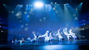 A scene from the Hip Hop Nutcracker with dancers in white and a blue background.
