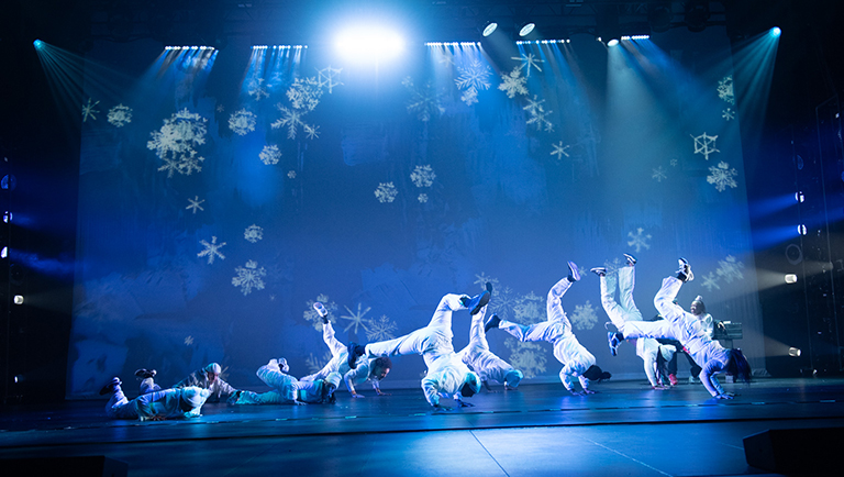 A scene from the Hip Hop Nutcracker with dancers in white and a blue background.