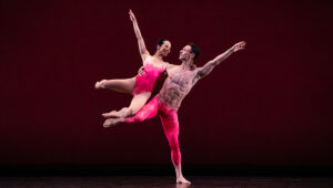 A pair of Paul Taylor Dance company dancers, one male and one female, in pink costumes.