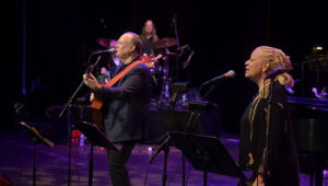 Rob Mathes playing guitar on stage accompanied by a woman singing